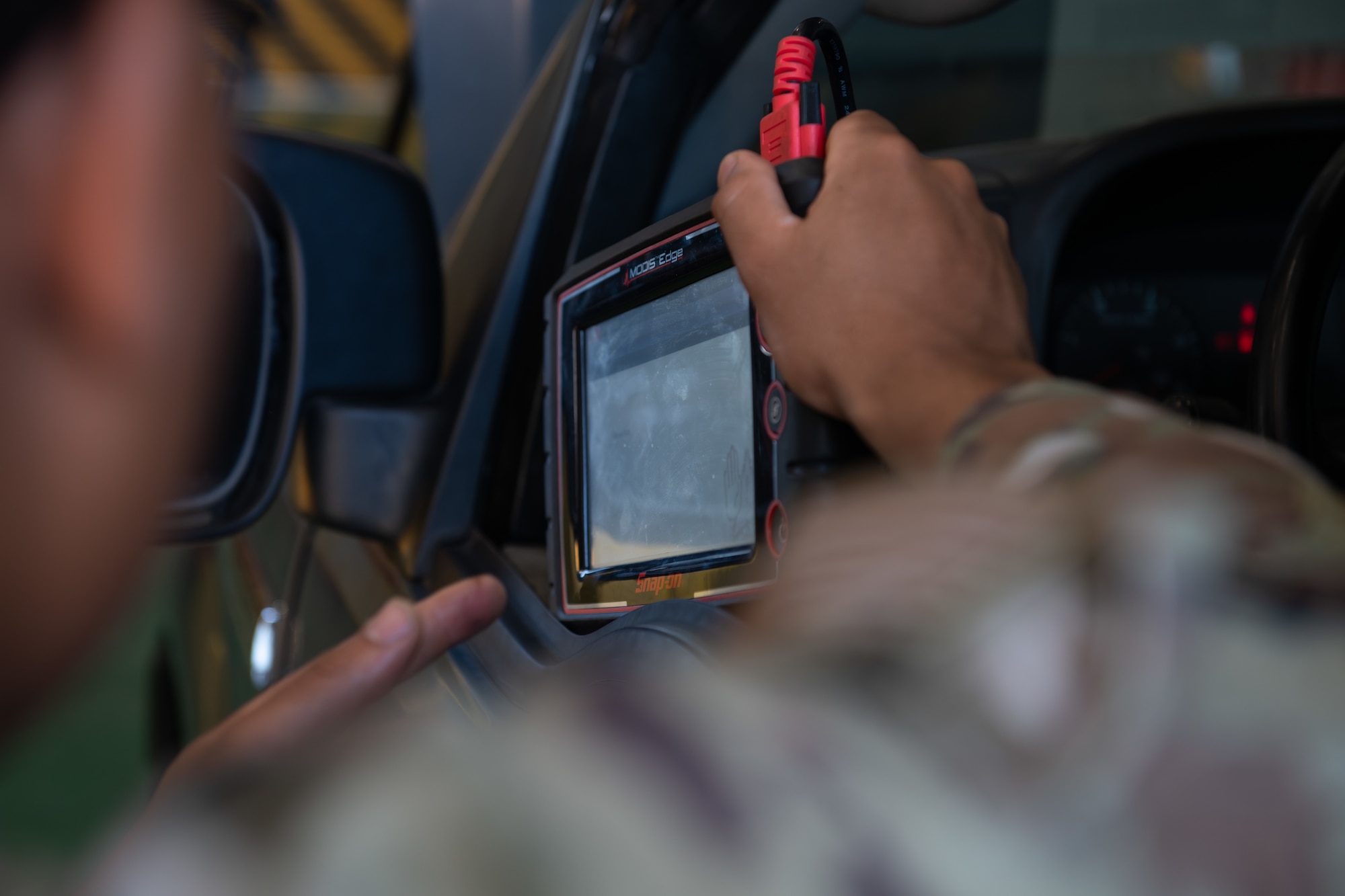 An Airman holds a vehicle diagnostic computer