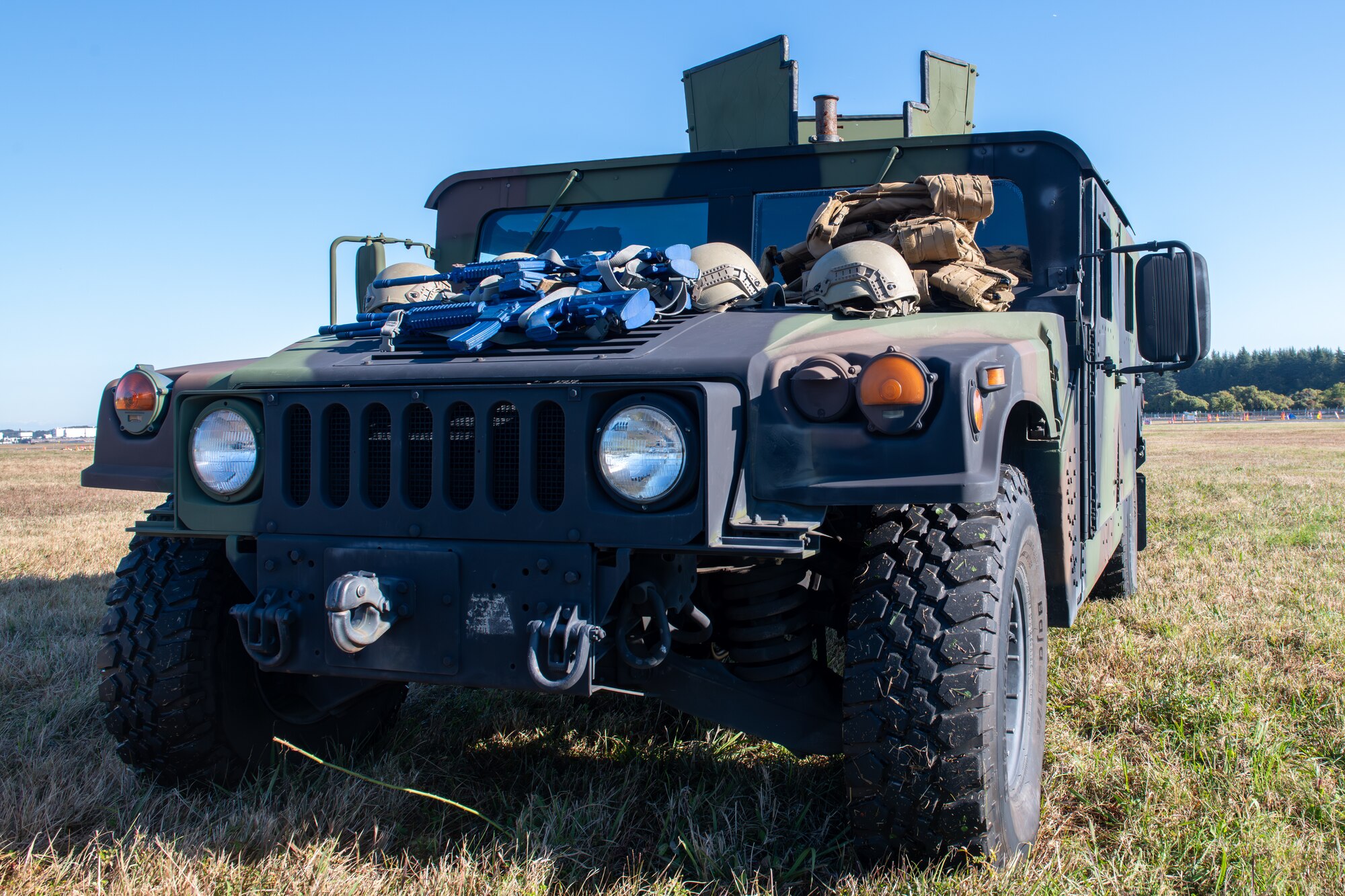 A camouflaged colored armored vehicle sits in a field