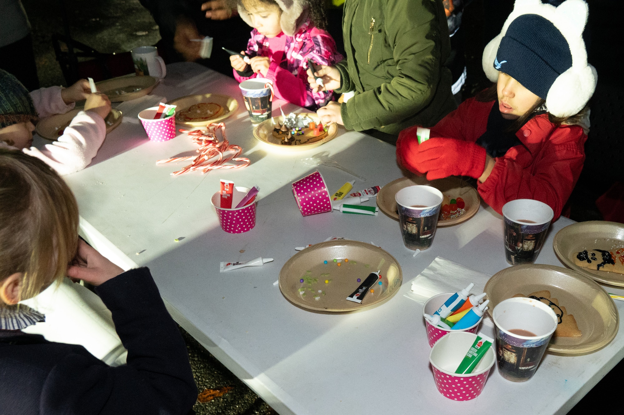 Children decorate cookies during a Christmas tree lighting ceremony