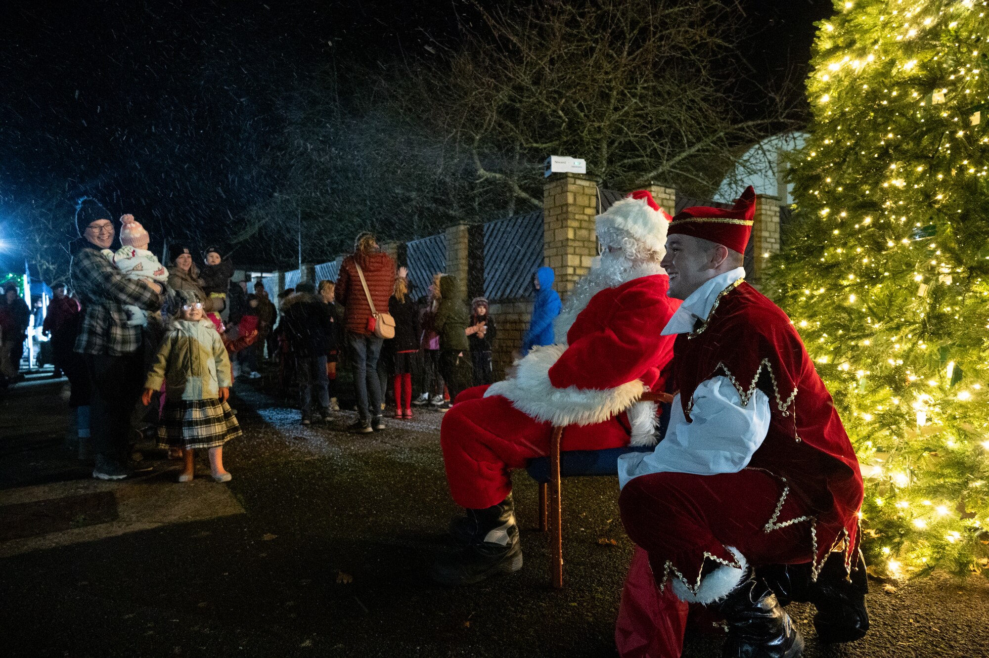 Santa Claus and his elf talk with pathfinders during a Christmas tree lighting ceremony