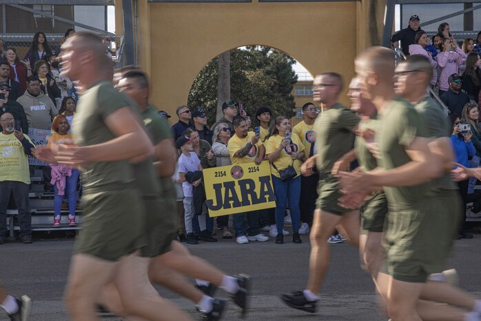 Friends and families of Golf Company, 2nd Recruit Training Battalion, cheer on their new Marines during the company motivational run at Marine Corps Recruit Depot San Diego, California, Nov. 25, 2024. The company motivational run is a three-mile cadence run conducted around the Depot, the last physical training event the Marines will conduct before they graduate from MCRD San Diego and the first time their friends and families will see their newly transformed U.S. Marines. (U.S. Marine Corps photo by Cpl. Alexandra M. Earl)