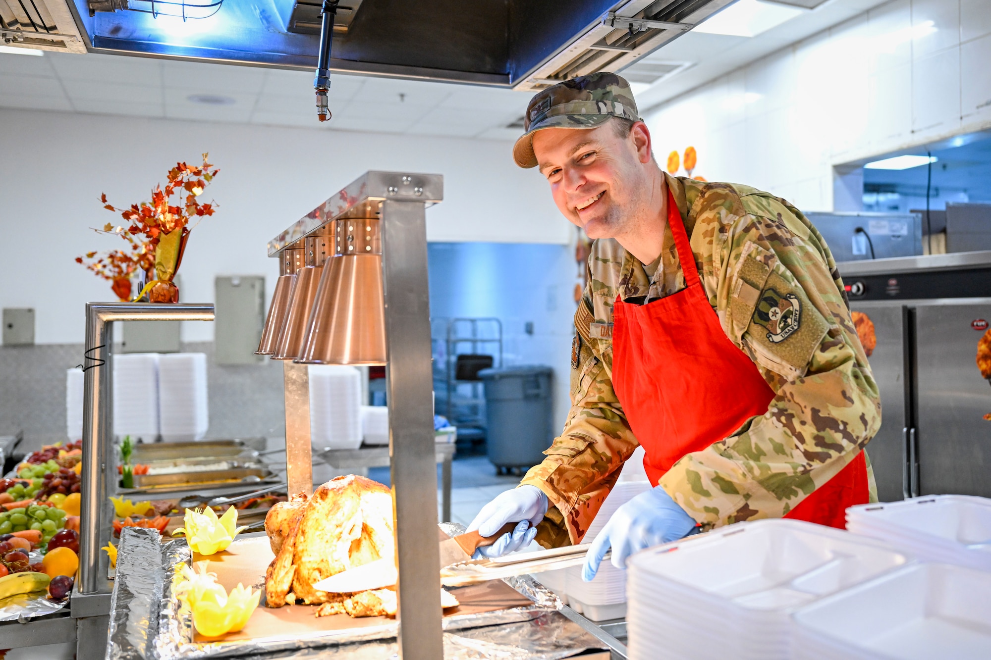 A commander carves a turkey during a Thanksgiving meal in the dining facility.