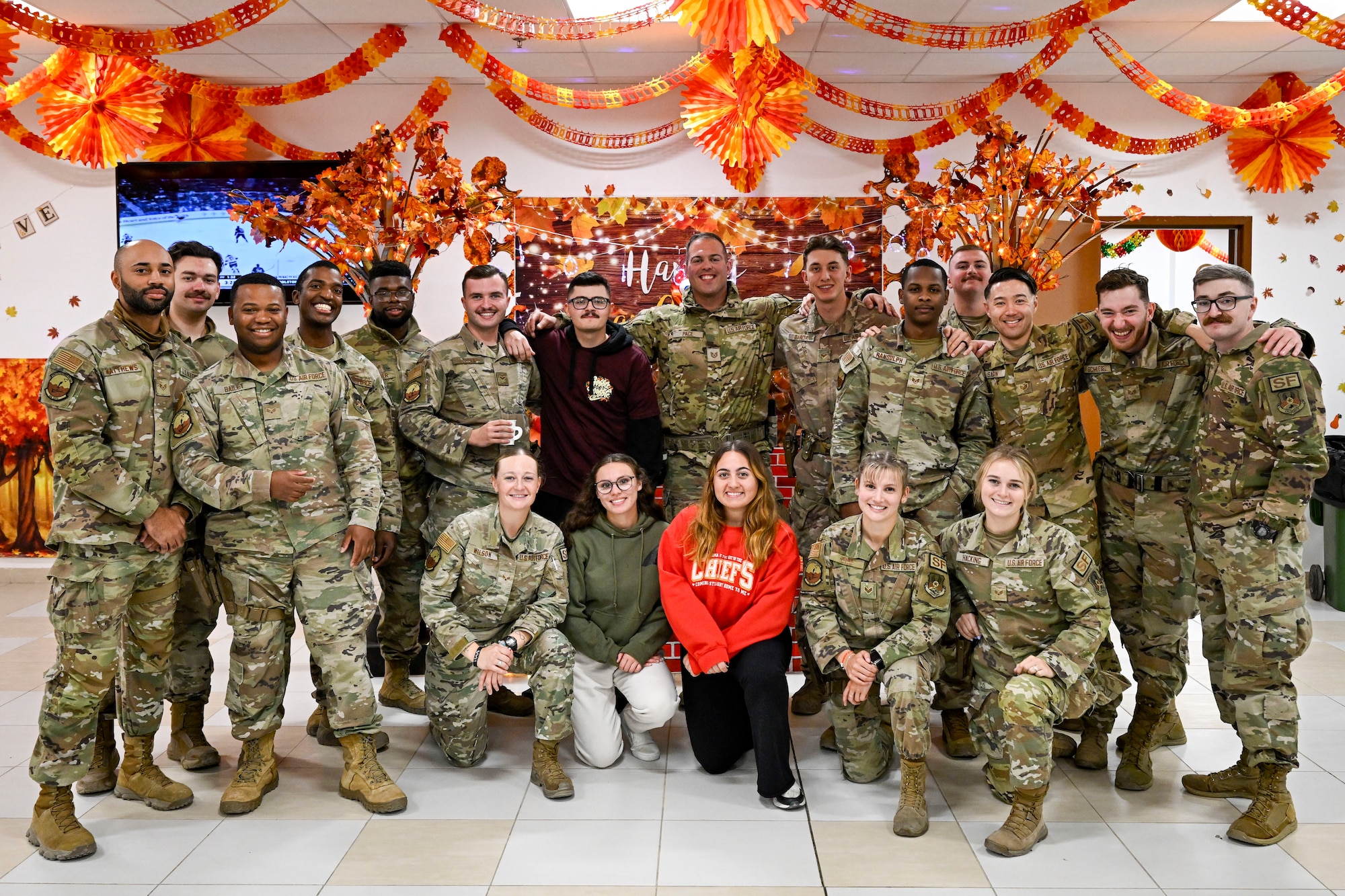 A group of Airmen take a photo during a Thanksgiving meal.