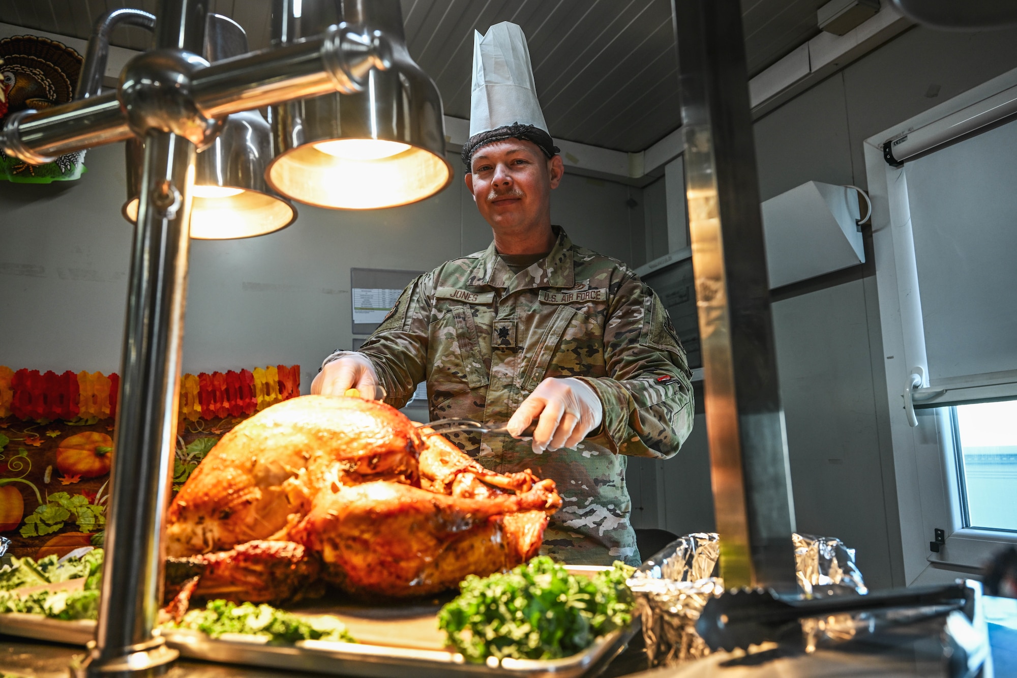 A commander carves a turkey during a Thanksgiving meal at a dining facility.