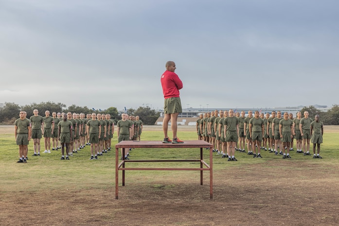 U.S. Marine Corps Chief Drill Instructor Gunnery Sgt. Crescenciano Reyes, center, with Bravo Company, 1st Recruit Training Battalion, guides recruits through dynamic warm-ups prior to a physical training event at Marine Corps Recruit Depot San Diego, California, Nov. 27, 2024. The recruits conducted a series of stations such as side shuffles, ammunition can lifts, planks, single-leg Romanian deadlifts, bicycle crunches, and 440-yard sprints during their physical training event, strengthening themselves physically and mentally. (U.S. Marine Corps photo by Cpl. Alexandra M. Earl)