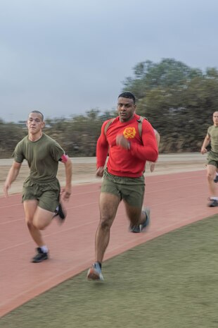 U.S. Marine Corps Drill Instructor Sgt. Manuel Delarosa, right, with Bravo Company, 1st Recruit Training Battalion, guides recruits through a 440-yard sprint during a physical training event at Marine Corps Recruit Depot San Diego, California, Nov. 27, 2024. The recruits conducted a series of stations such as side shuffles, ammunition can lifts, planks, single-leg Romanian deadlifts, bicycle crunches, and 440-yard sprints during their physical training event, strengthening themselves physically and mentally.  (U.S. Marine Corps photo by Cpl. Alexandra M. Earl)