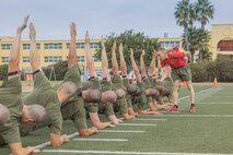 U.S. Marine Corps Drill Instructor Staff Sgt. Christopher Javner, right, with Bravo Company, 1st Recruit Training Battalion, observes recruits executing a side plank during a physical training event at Marine Corps Recruit Depot San Diego, California, Nov. 27, 2024. The recruits conducted a series of stations such as side shuffles, ammunition can lifts, planks, single-leg Romanian deadlifts, bicycle crunches, and 440-yard sprints during their physical training event, strengthening themselves physically and mentally. (U.S. Marine Corps photo by Cpl. Alexandra M. Earl)