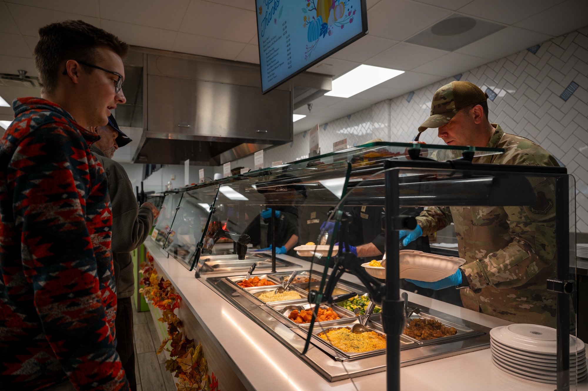 U.S. Air Force Senior Master Sgt. Dennis Kolesnik, right, the Nevada Test and Training Range senior enlisted leader, serves Thanksgiving meals at the Crosswinds Dining Facility, Nellis Air Force Base, Nevada, Nov. 28, 2024.