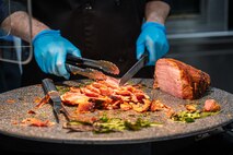 U.S. Air Force Brig. Gen. Lawrence Sullivan, the 57th Wing commander, carves a baked ham with peach glaze during Thanksgiving at the Crosswinds Dining Facility, Nellis Air Force Base, Nevada, Nov. 28 2024.