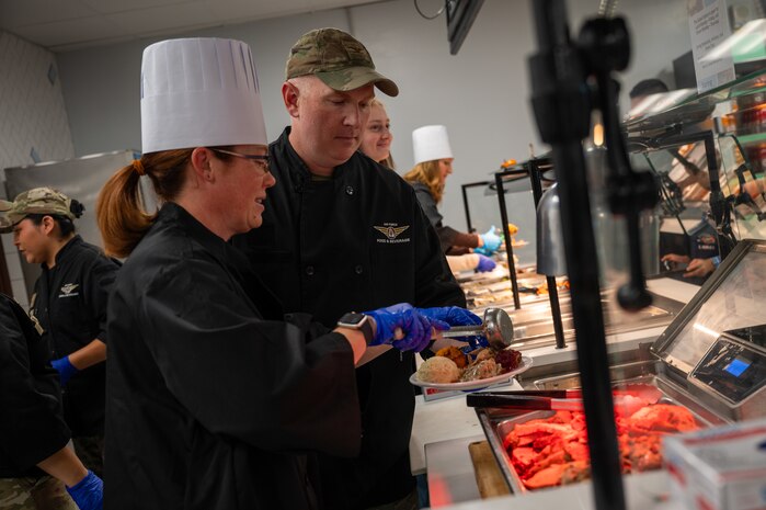 U.S. Air Force Col. Jason Wild, right, the 99th Air Base Wing deputy commander and his wife Drea Wilde serve a Thanksgiving meal at the Crosswinds Dining Facility, Nellis Air Force Base, Nevada, Nov. 28, 2024.