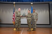An Airman receives an award from U.S. Air Force Col. Jason Glynn.