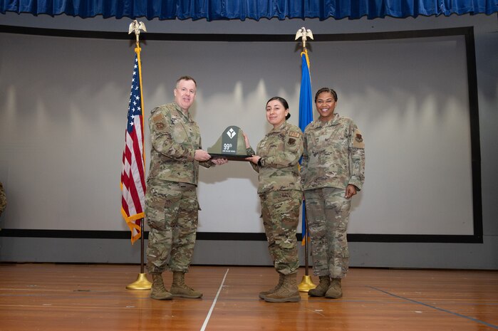 An Airman receives an award from U.S. Air Force Col. Jason Glynn.