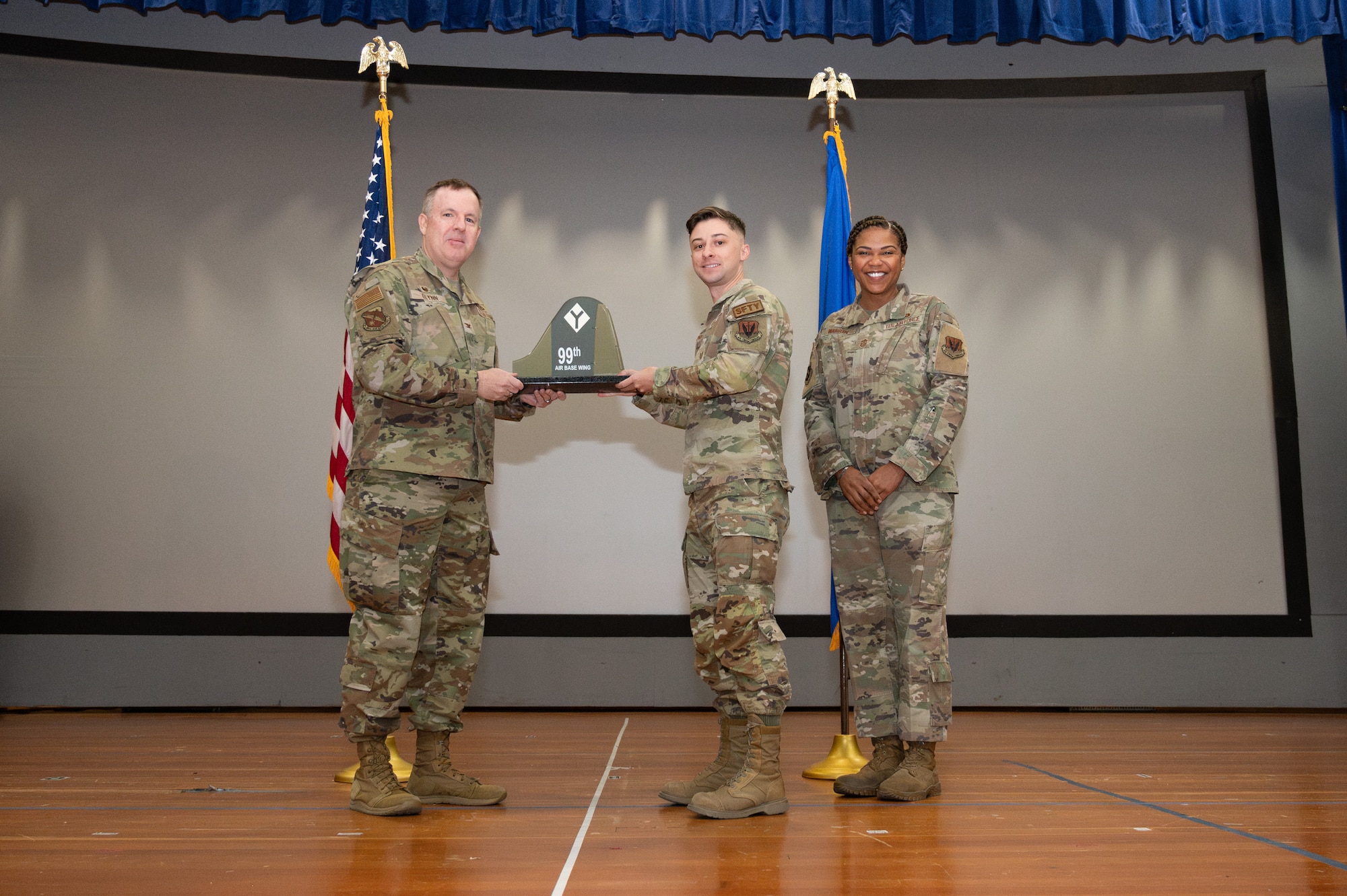 An Airman receives an award from U.S. Air Force Col. Jason Glynn.