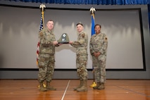 An Airman receives an award from U.S. Air Force Col. Jason Glynn.