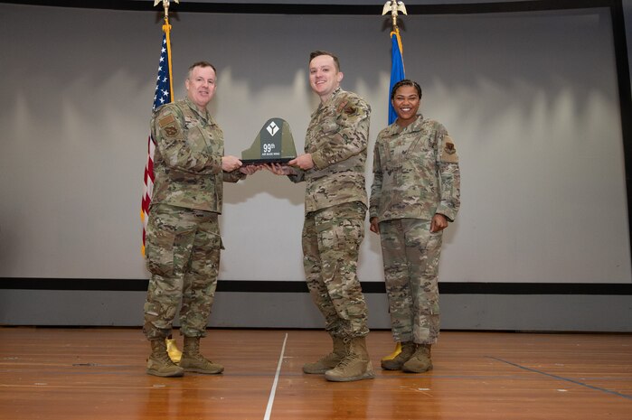 An Airman receives an award from U.S. Air Force Col. Jason Glynn.