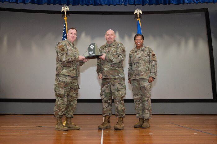 An Airman receives an award from U.S. Air Force Col. Jason Glynn.