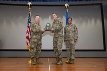 An Airman receives an award from U.S. Air Force Col. Jason Glynn.
