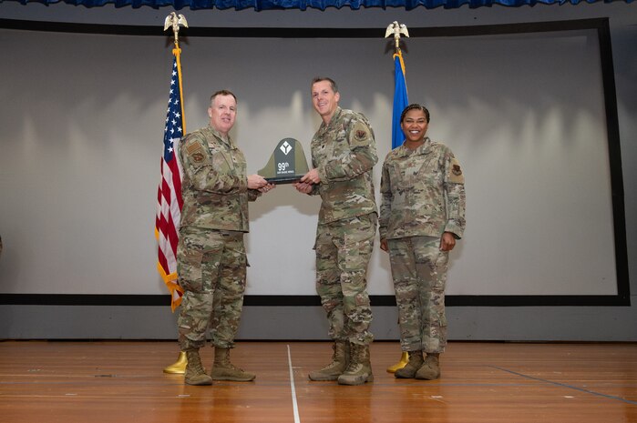 An Airman receives an award from U.S. Air Force Col. Jason Glynn.