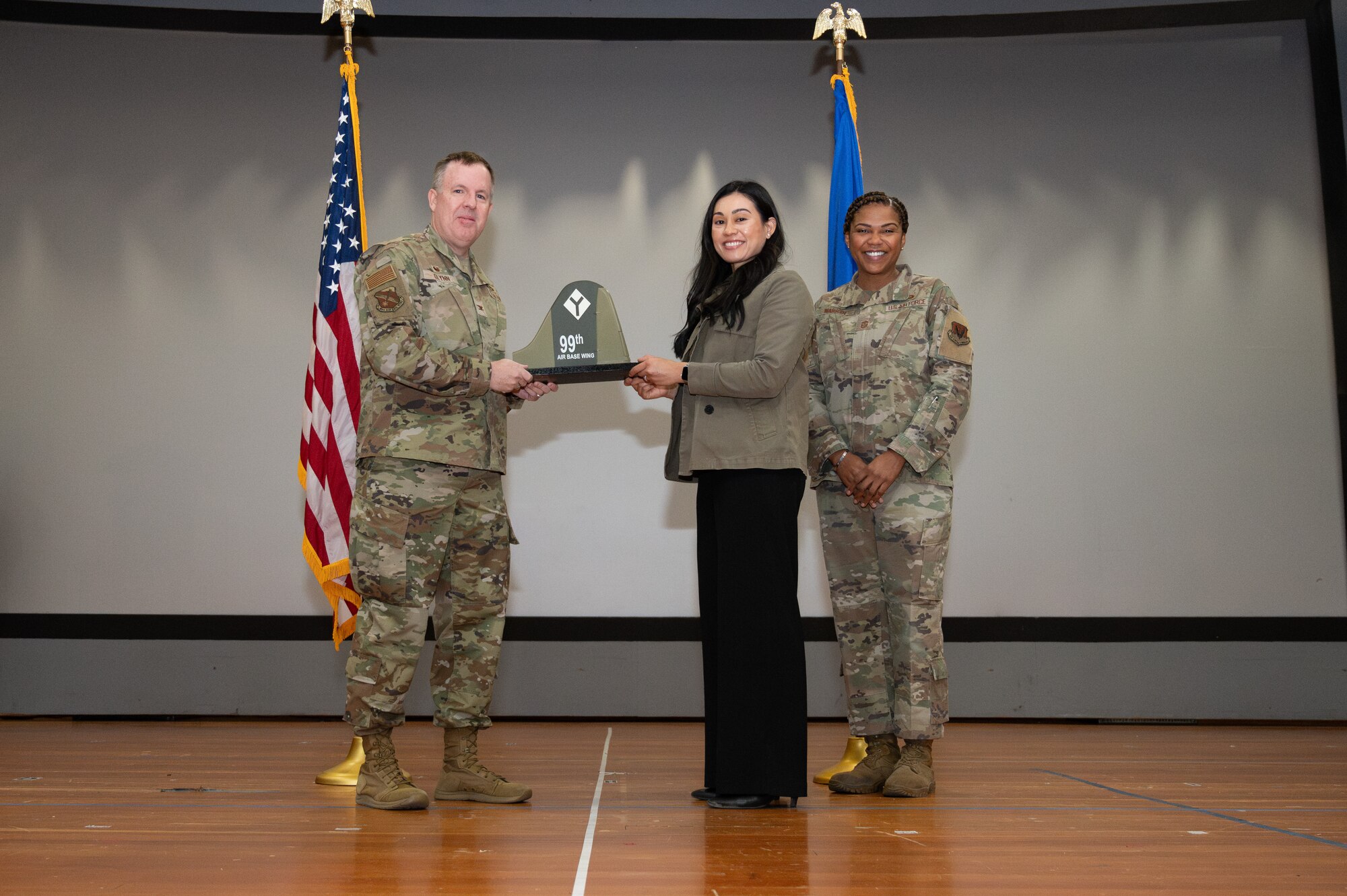 A woman receives an award from U.S. Air Force Col. Jason Glynn.