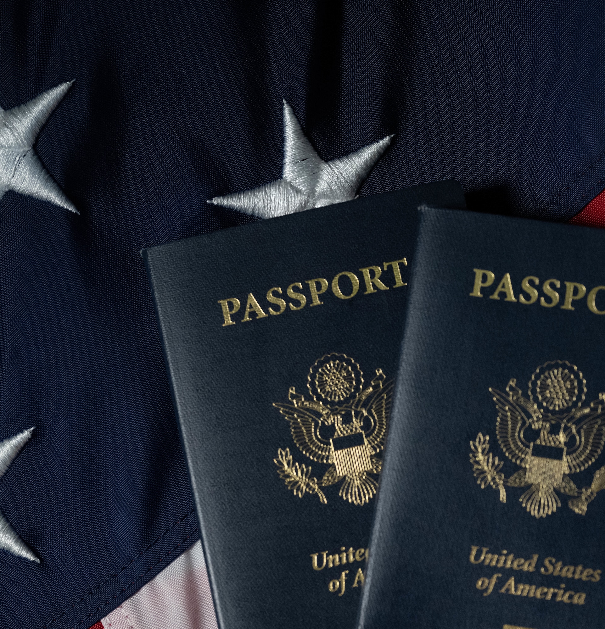 Two U.S. passports rest on an American flag. The first U.S. passports were issued in 1775 as paper certificates before being issued. (U.S. Air Force photo by Airman 1st Class Wesley Davies)
