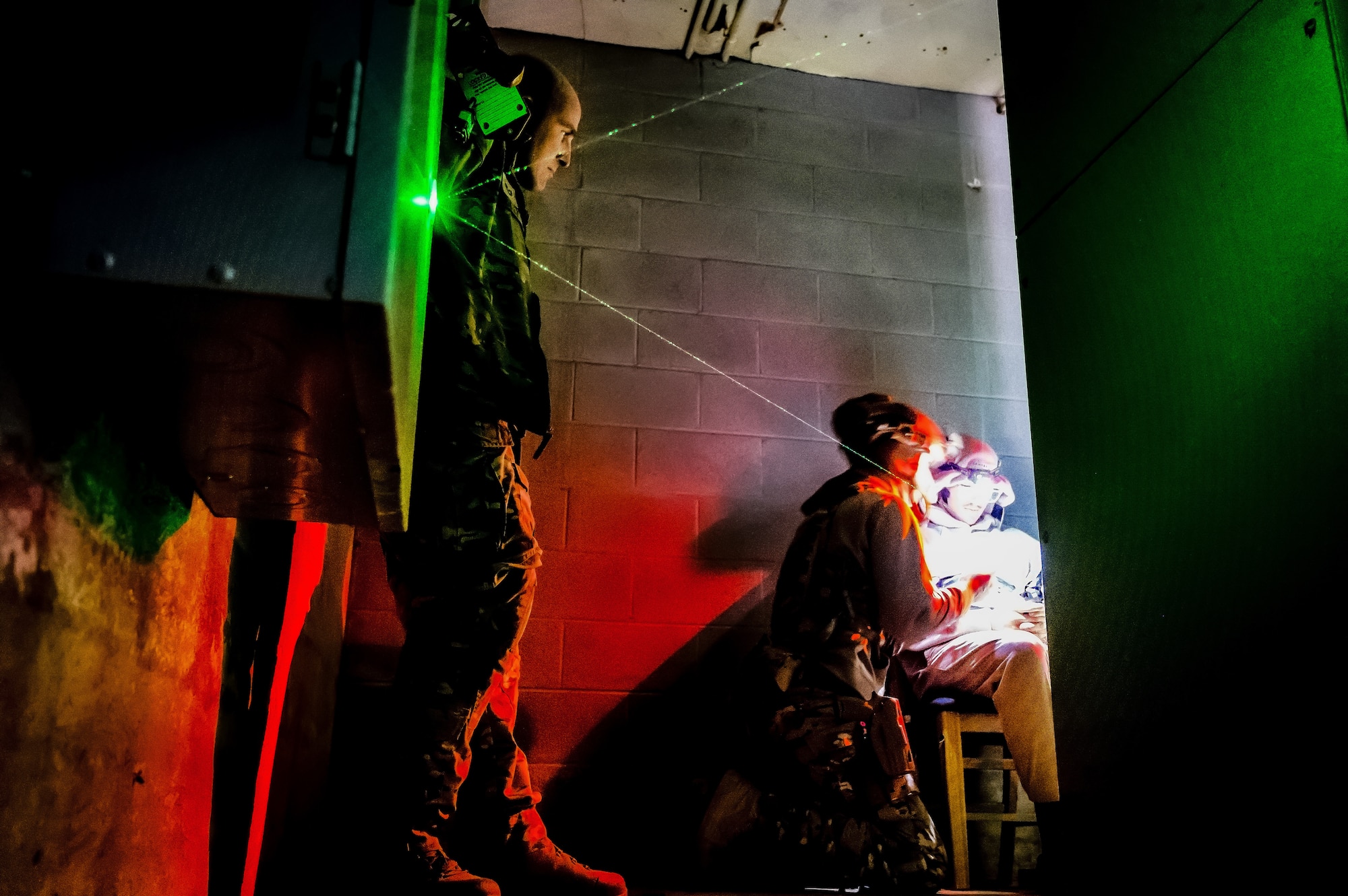 U.S. Air Force Senior Airman Carson Gregg, Senior Airman Jacob Albright, 87th Civil Engineer Squadron explosive ordnance disposal technicians, simulate an explosive disarmament on a hostage at Joint Base McGuire-Dix-Lakehurst, N.J., Nov. 15, 2024. The 87th CES EOD underwent a four-day training involving three teams of three technicians who worked through 20 intricate scenarios as part of an annual training qualification. (U.S. Air Force photo by Senior Airman Matt Porter)