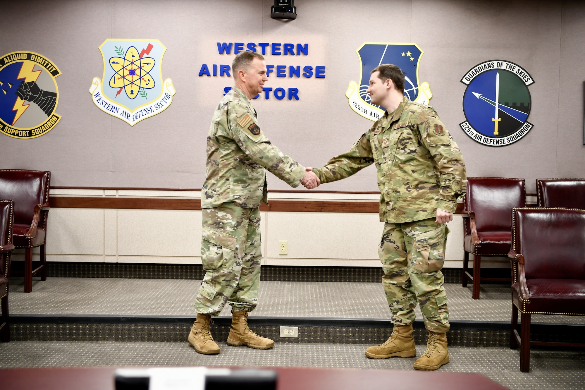 The NORAD commander shakes Staff Sgt. Ezra Young's hand.