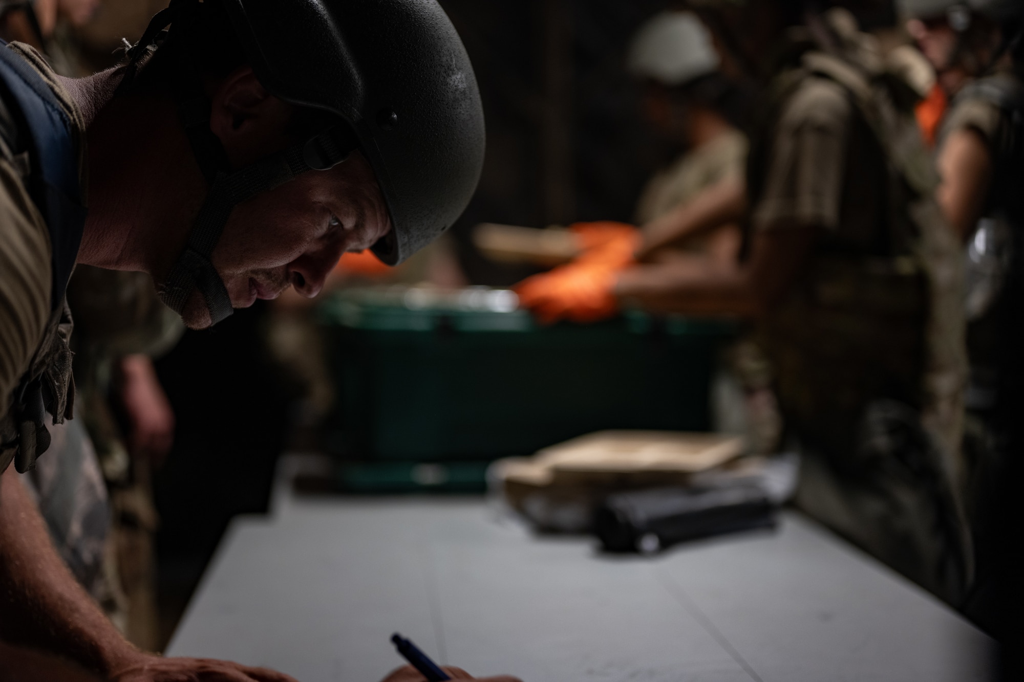 A U.S. Airman assigned to the 1st Special Operations Mission Support Group signs their name on a roster sheet before getting dinner during a bivouac exercise at Eglin Range, Eglin Air Force Base, Florida, Nov. 5, 2024. During the exercise, participants honed their skills in tactical operations, including weapons handling, tactical combat casualty Care, dismounted patrols, and operational security, while demonstrating their ability to survive and operate in an austere environment. (U.S. Air Force photo by Senior Airman Hussein Enaya)