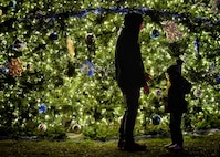 Community members at Joint Base San Antonio-Lackland, Texas, take part in a holiday tree lighting ceremony Nov. 30, 2022 at the Gateway Club