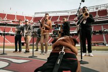 U.S. Marine Corps Lance Cpl. Bruno, theMarine Corps Recruit Depot San Diego, Western Recruiting Region mascot, poses for a photo in front of Marine Band San Diego while they rehearse before the San Francisco 49ers Salute to Service game vs. the Seattle Seahawks at Levi’s Stadium Santa Clara, California. Nov. 17, 2024. Bruno attended the Salute to Service game to help honor the nation's service members, veterans and their families. (U.S. Marine Corps photo by Cpl. Sarah M. Grawcock)