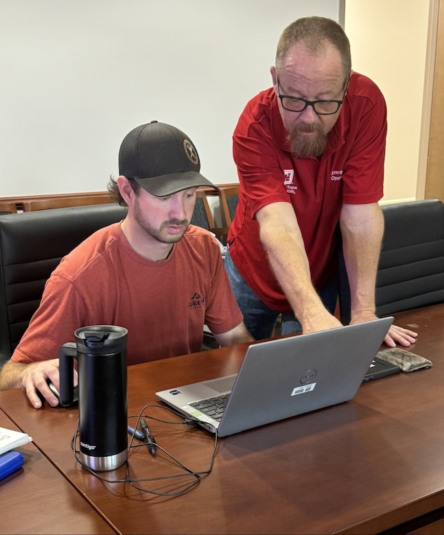 Two USACE male employees looking at a laptop computer