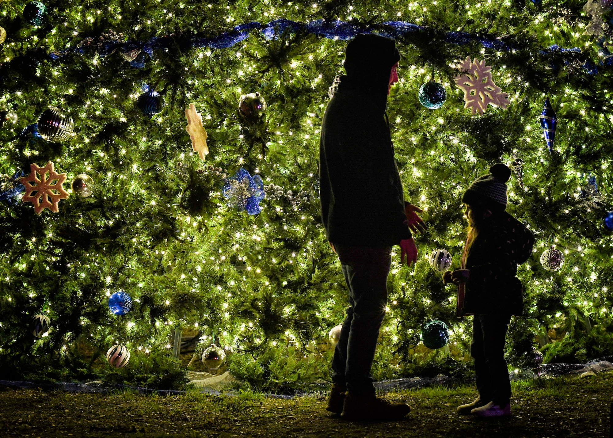 Community members at Joint Base San Antonio-Lackland, Texas, take part in a holiday tree lighting ceremony Nov. 30, 2022 at the Gateway Club