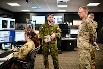 Gen. Gregory Guillot, commander, North American Aerospace Defense Command and U.S. Northern Command, and Chief Master Sgt. John Storms, NORAD and USNORTHCOM Command senior enlisted leader, are briefed on the Western Air Defense Sector’s Agile Operations Center air picture management section by Royal Canadian Air Force Sgt. Guillaume Thibault at Joint Base Lewis-McChord, Wash., Nov. 18, 2024.