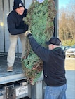 New York Army National Guard Spc. Matt Clark lifts a donated Christmas tree from retired Command Sgt. Maj. Bob Van Pelt during the annual Trees for Troops loadout at Ellms Tree Farm in Ballston Spa, New York, Dec. 2, 2024. Tree farmers from New York’s capital and Saratoga regions donated 125 trees to be sent to military bases for the holidays.