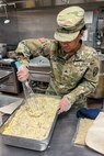 New York Army National Guard Sgt. Judith Dallemand with the 1501st Quartermaster Company (Field Feeding), 369th Sustainment Brigade, prepares food during the 42nd Infantry Division’s command post exercise at Fort Indiantown Gap, Pa., Nov. 24, 2024. This was the 1501st FFC’s first official large-scale support mission. (U.S. Army National Guard photo by 2nd Lt. Rivkah Weissberger)