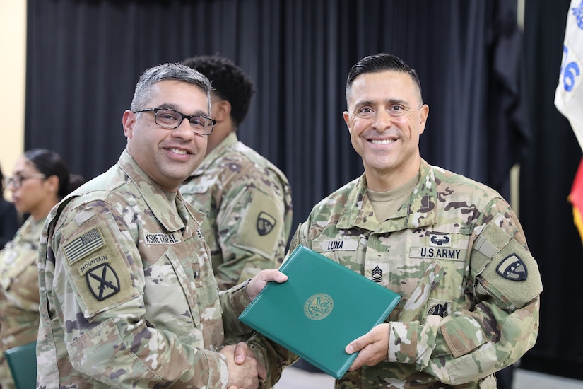 A leader presents an award to a Soldier.