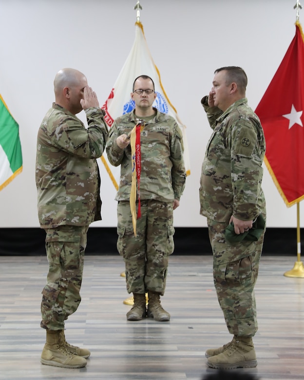 Leaders of the 690th Quartermaster Detachment uncase their unit guidon and salute the guidon.