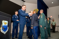 Col. Bryan Tuinman, Commandant of the Inter-American Air Forces Academy, pins Lt. Constancia Nzang Abaga of Equitorial Guinea’s National Gendarmarie during a graduation ceremony at Joint Base San Antonio-Lackland, Texas, Oct. 17, 2024.