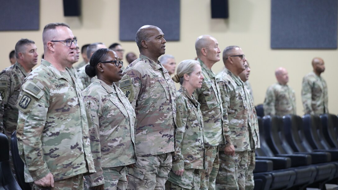 Leaders stand to sing the Army Song.