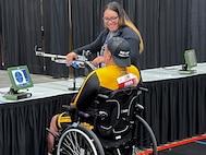 Gloriah Peko assists her husband, Sgt. 1st  Jack Peko, in a shooting competition at the 2024 DOD Warrior Games