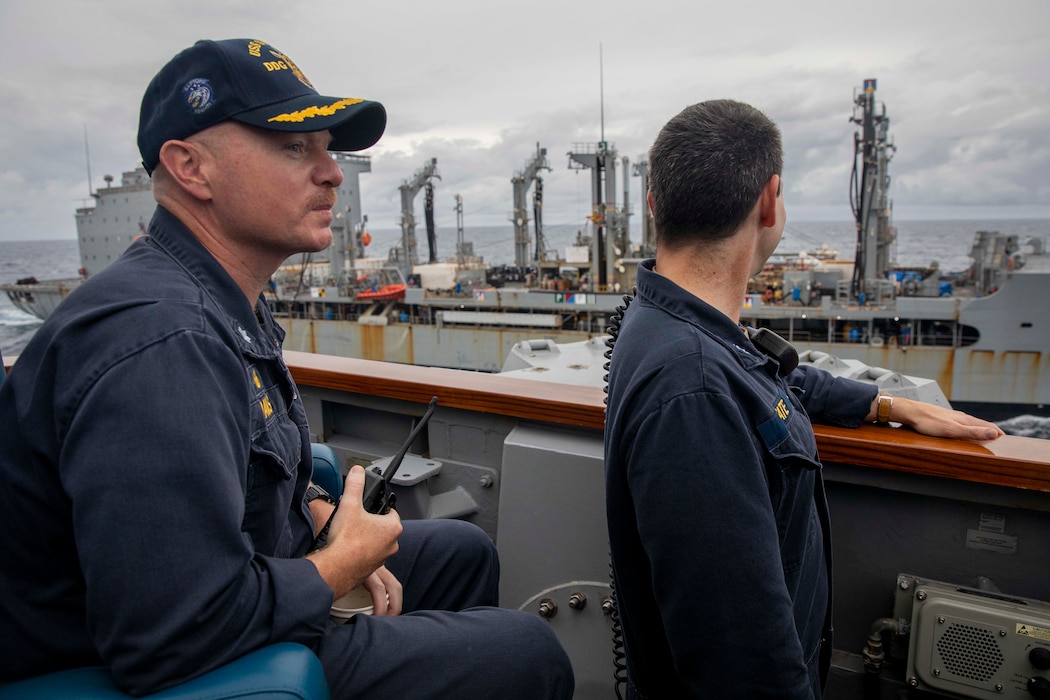 Cmdr. Matt Adams, left, and Cmdr. Leigh Tate oversee a replenishment-at-sea aboard USS Spruance (DDG 111) with USNS Rappahannock (T-AO 204) in the South China Sea.