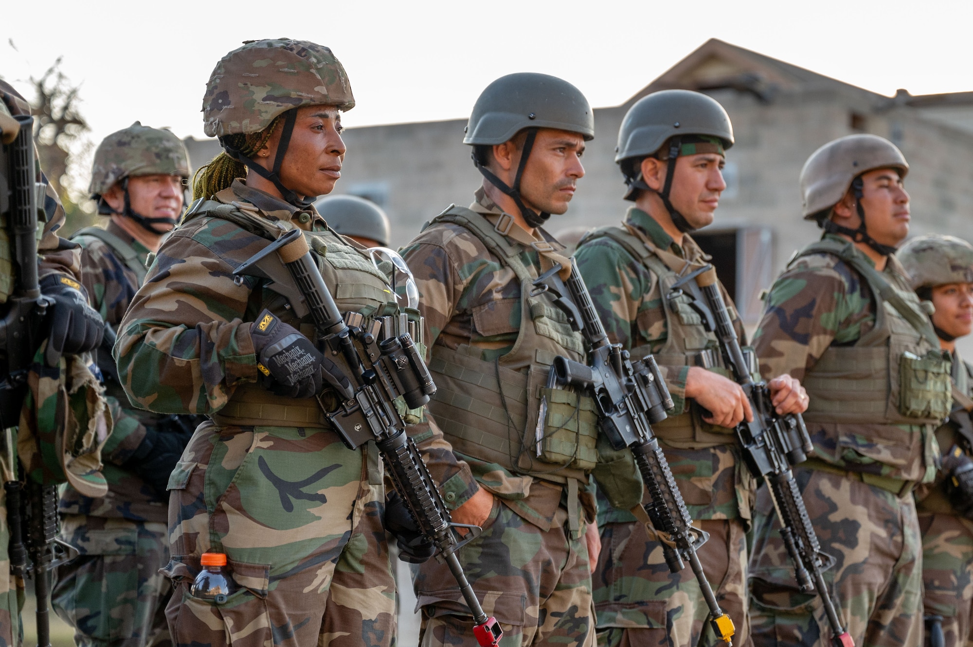 Lt. Constancia Nzang Abaga of Equitorial Guinea's National Gendarmarie and students from the Inter-American Air Force's Academy's Ground Defense Leadership Course hold training weapons after conducting a capstone exercise, Oct. 11, 2024 at Joint Base San Antonio-Camp Bullis, Texas.