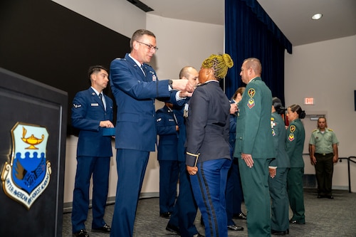 Col. Bryan Tuinman, Commandant of the Inter-American Air Forces Academy, pins Lt. Constancia Nzang Abaga of Equitorial Guinea’s National Gendarmarie during a graduation ceremony at Joint Base San Antonio-Lackland, Texas, Oct. 17, 2024.