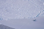 Submarine appearing through ice, parachuters landing on ice field