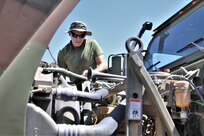 Marine looks over engine of vehicle