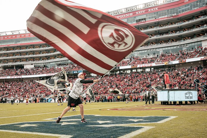 A participant of the San Francisco 49ers Salute to Service game vs. the Seattle Seahawks waves a flag at Levi’s Stadium Santa Clara, California. Nov. 17, 2024. U.S. service members participated in the Salute to Service game to help honor the nation's service members, veterans and their families. (U.S. Marine Corps photo by Cpl. Sarah M. Grawcock)