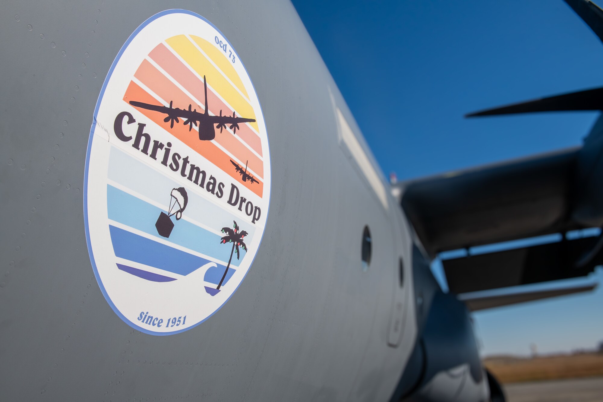 A colorful logo is displayed on the side of a grey aircraft.