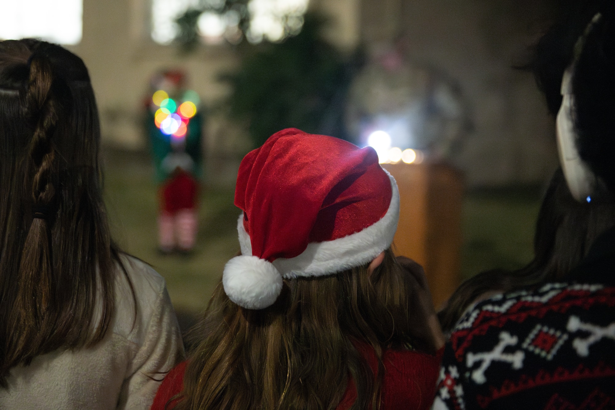 Community members wear a red and white santa hat to the tree lighting ceremony
