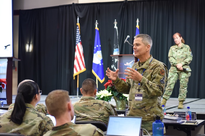 Image of an Airman talking to a group of people.