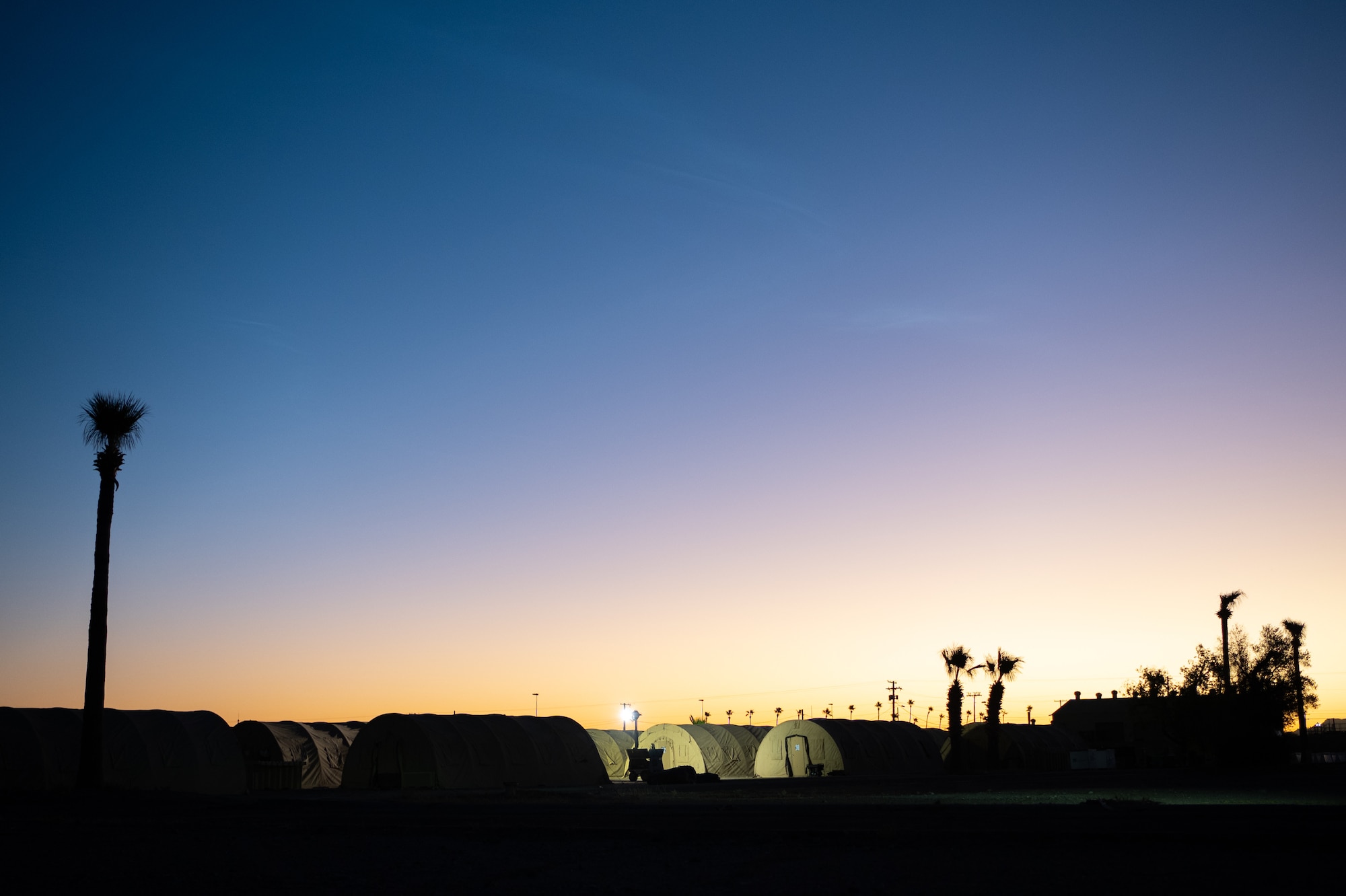 The sun rises over the 944th Fighter Wing basecamp during Exercise Desert Hammer 25-1 at Gila Bend Air Force Auxiliary Field, Ariz., Nov. 14, 2024. Set against the unmatched backdrop of the Barry M. Goldwater Range, Desert Hammer leverages Arizona’s strategic geography to provide realistic combat training for U.S. and allied forces. (U.S. Air Force photo by Tech. Sgt. Tyler J. Bolken)