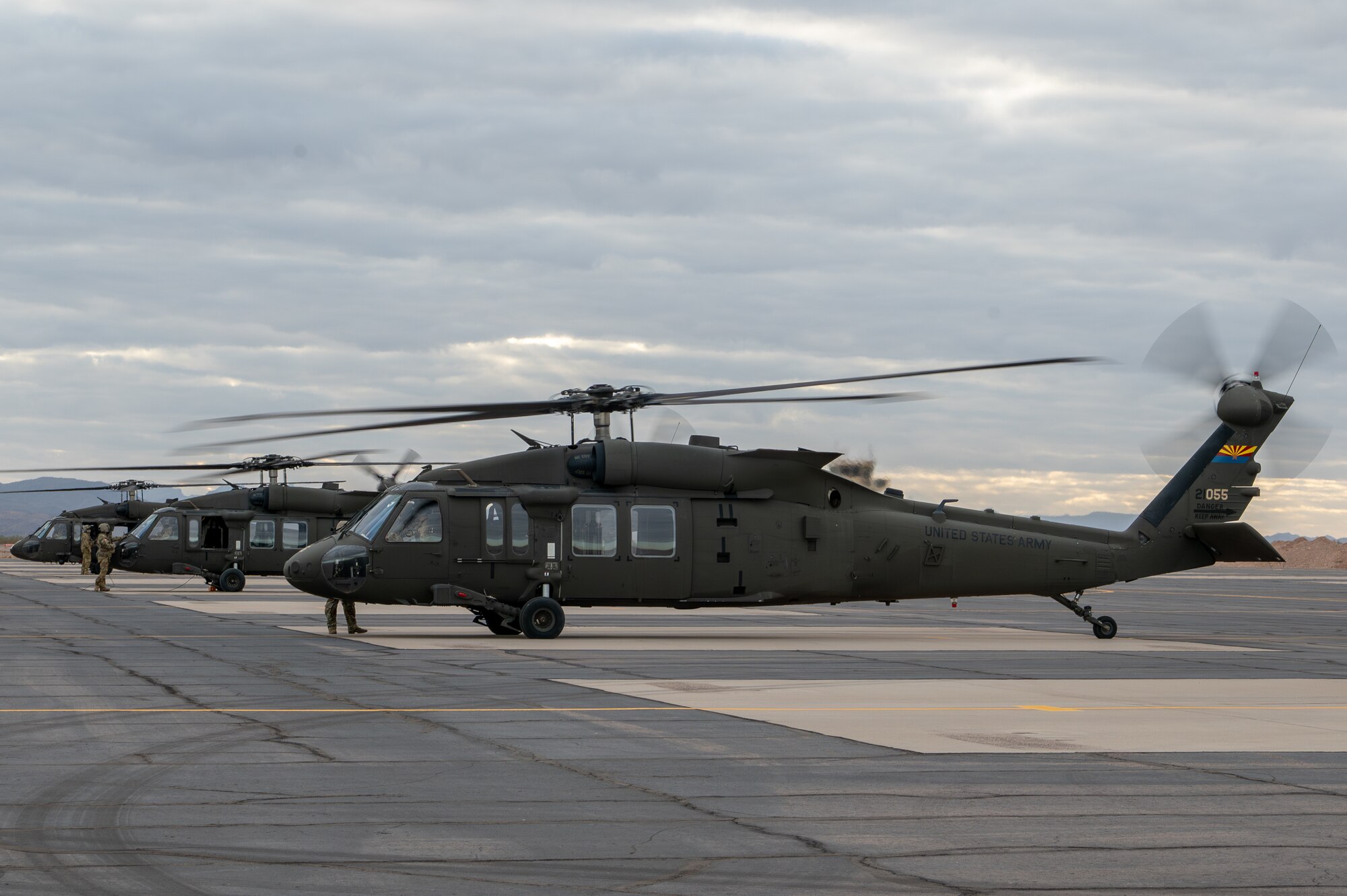 A line of Arizona Army National Guard UH-60 Black Hawk helicopters prepare for takeoff at Gila Bend Air Force Auxiliary Field near Gila Bend, Ariz., Nov. 16, 2024. Through joint and multinational collaboration, Desert Hammer tests the ability of over 700 participants and 131 aircraft to operate, defend, and sustain airbases under austere conditions. (U.S. Air Force photo by Senior Airman Alexis Orozco)